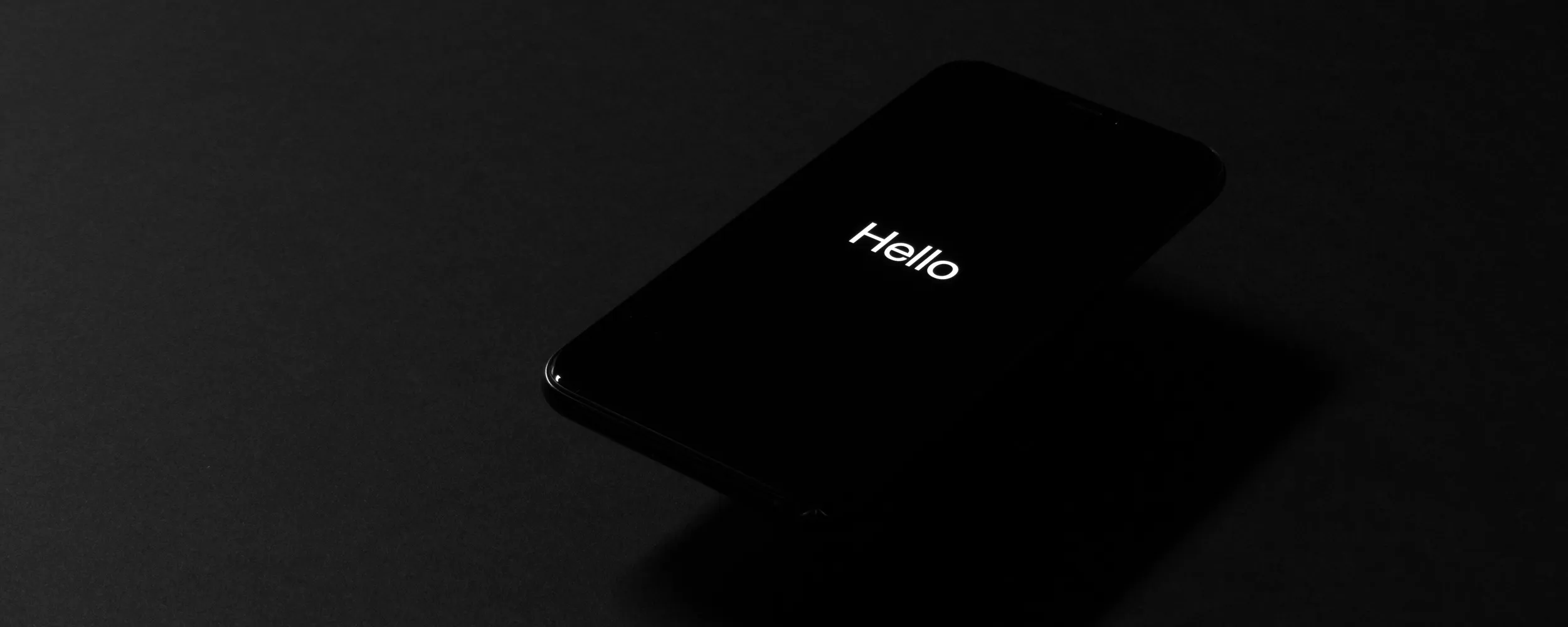 An iPhone displaying "Hello" on its screen